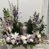 Lavender and white floral arrangement around a silver urn