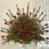 Large arrangement of red roses in a decorative pedestal vase