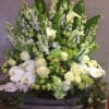 Large white and green floral arrangement with orchids and calla lilies