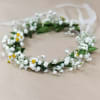 White floral crown with small yellow daisies on a ribbon tie