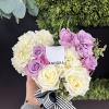 Heart-shaped bouquet of white, pink, and lavender roses with a striped ribbon
