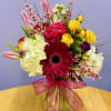 Mixed bouquet in a glass vase with pink, yellow, white, and red flowers