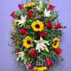Standing spray with red roses, white lilies, and yellow sunflowers