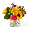 Mixed bouquet of bright flowers in a clear glass vase