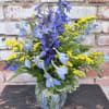 A tall spray of sky-blue delphinium-like blooms gives this everyday bouquet an