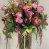 Pink roses and mixed blooms arranged in a clear glass vase