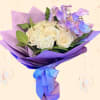 Bouquet of white roses and purple orchids wrapped in lavender paper