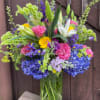Vivid pink roses and sky-blue hydrangeas create an immediate joyful splash-this mixed-color