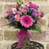 Pink and purple mixed bouquet in a glass vase with a ribbon