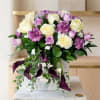 Bouquet of cream and lavender roses with purple calla lilies in a white box