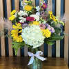 Mixed bouquet in a glass vase with a white ribbon