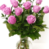 Soft pink roses gathered in a clear glass vase create a timeless