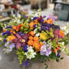 Colorful mixed bouquet with orange roses, purple orchids, and yellow accents