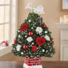 Christmas tree-shaped floral arrangement with red roses and white flowers