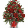Red roses and carnations in a red glass vase with pinecones