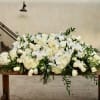 Large white floral arrangement on a wooden table