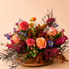 Colorful mixed flower arrangement in a low wooden bowl