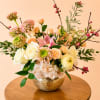 Mixed pastel flower arrangement in a gold bowl vase