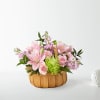 Pink lilies and mixed flowers arranged in a woven basket