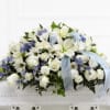 White and blue funeral casket spray with ribbon