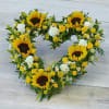 A bright mix of striking sunflowers, mini roses and fillers in an