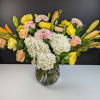 Mixed bouquet of hydrangeas, roses, and chrysanthemums in a glass vase