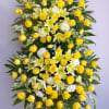 Standing floral spray with yellow roses, white lilies, and white mums