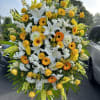 Large standing spray of white lilies, yellow roses, and orange gerbera daisies
