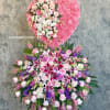 Large heart-shaped floral tribute with pink and white flowers on an easel