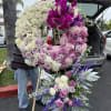 Large floral wreath with pink, purple, and white roses on an easel