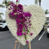 Heart-shaped white floral spray with purple orchids and roses