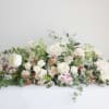 Low floral arrangement with white and blush roses on a table
