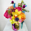 Bright mixed bouquet with orchids, roses, and calla lilies in a metallic vase