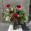 Mixed bouquet of red roses and white lilies in a clear glass vase