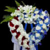 A large heart-shaped sympathy arrangement that reads with quiet dignity: white lilies
