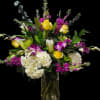 A bold cascade of yellow roses, white hydrangeas, purple Dendrobium orchids, and