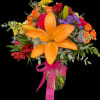 Colorful bouquet with orange lilies, roses, and purple flowers in a glass vase