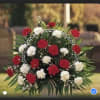 Round arrangement of red and white carnations with a decorative wire frame
