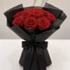 Bouquet of red roses wrapped in black paper with a black ribbon