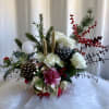 Holiday arrangement with white roses, pinecones, and red berries