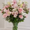 Large pink lilies and a pale pink rose create an immediate romantic