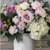 Blush and lavender blooms mingle in a soft, romantic arrangement perfect as