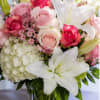 Soft white lilies and a cloud of white hydrangea meet blushing pink