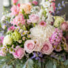 Soft pink and white roses mingle with a single large white hydrangea