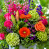 Bright pink roses and vibrant orange gerbera daisies pop against lime-green hydrangeas