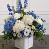 A tall, layered sympathy arrangement that reads as both formal and softly