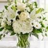 A serene cluster of pure white roses, lilies, hydrangeas, alstroemeria and daisy-like