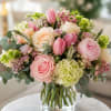 Soft blush and cream roses paired with pink tulips create a romantic