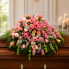 Soft mounds of pink and peach roses meet trumpet-shaped lilies in a