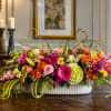 A long, low centerpiece awash in vivid pinks, purples, yellows and pops